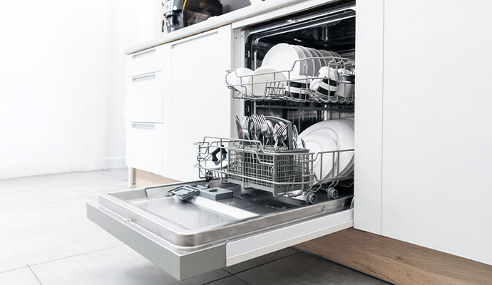 A open dishwasher showcasing clean white plates and cups