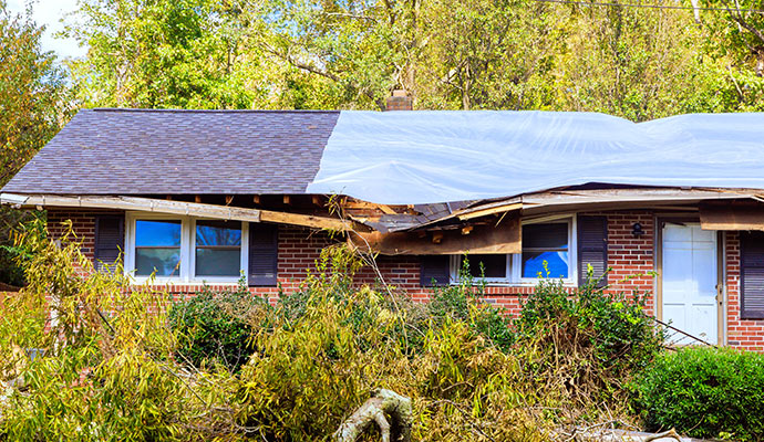 Storm damaged roof covered with tarp