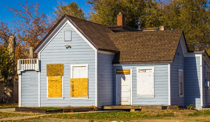 Boarded-up house with plywood windows