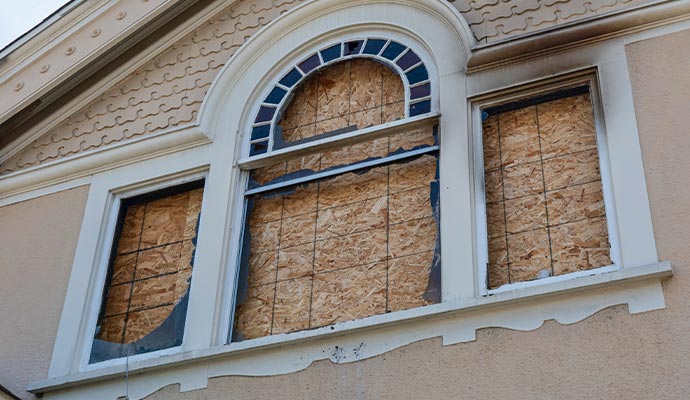 Boarded up windows in a fire damaged house