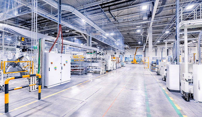 The clean and spacious interior of a modern manufacturing plant or factory floor with machinery