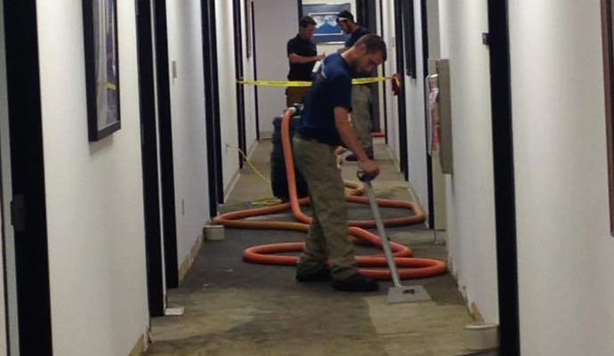 Professional team restoring water damaged floor with equipment