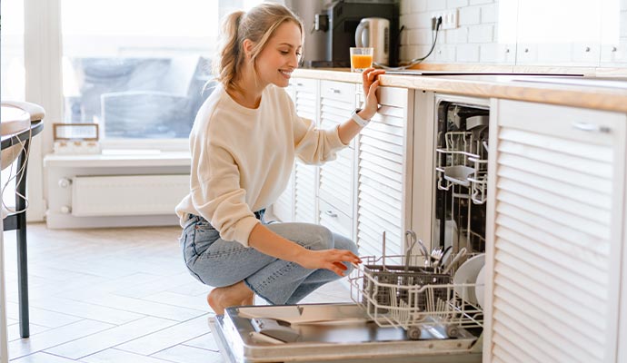 Woman using dishwasher